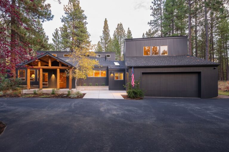 A clean, modern exterior with rustic timber accents creates a striking curb appeal in this Sisters, Oregon remodel.