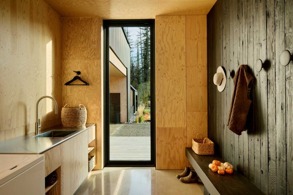 A warm and functional entryway featuring wood paneling, built-in storage, and a glass door to the outdoors.