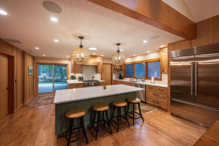 A beautifully remodeled kitchen with a spacious island, rustic wood finishes, and modern lighting that creates a warm, inviting atmosphere.
