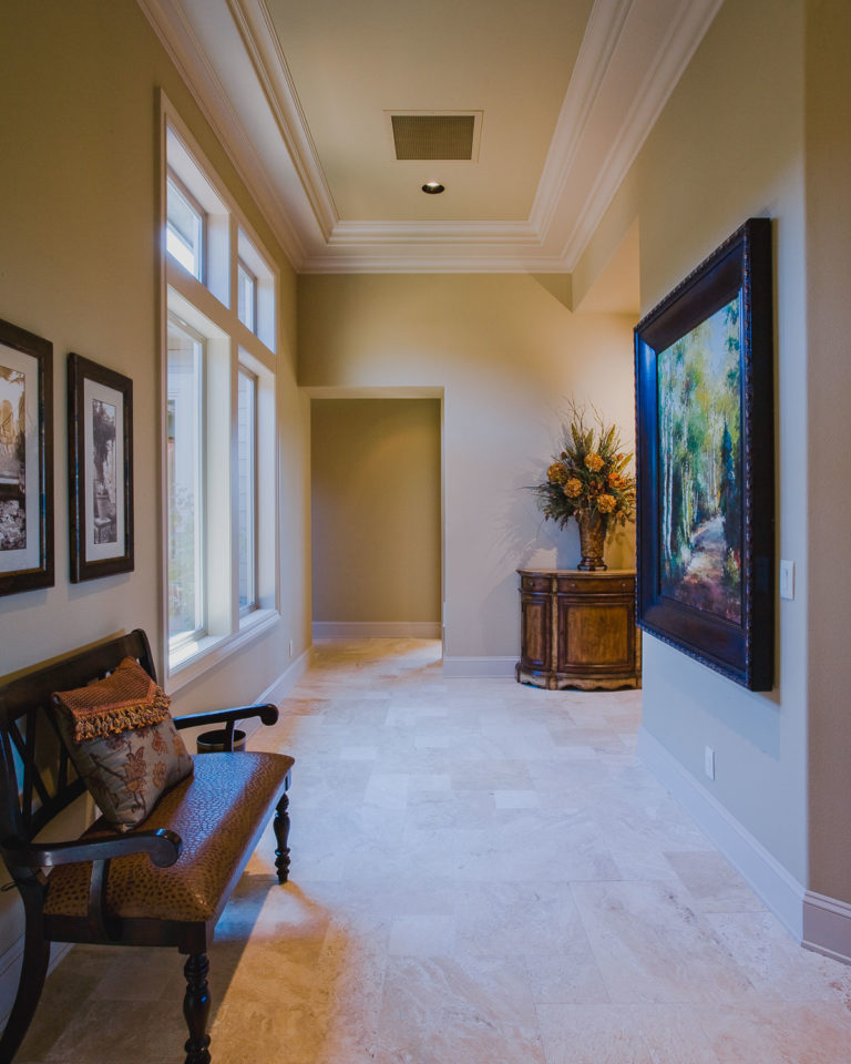 Travertine tile floor, crown mold, ceiling accent, casement window, baseboard