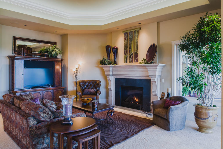 honed granite fireplace surround, paint grade mantel, accent lighting, crown mold, stepped ceiling