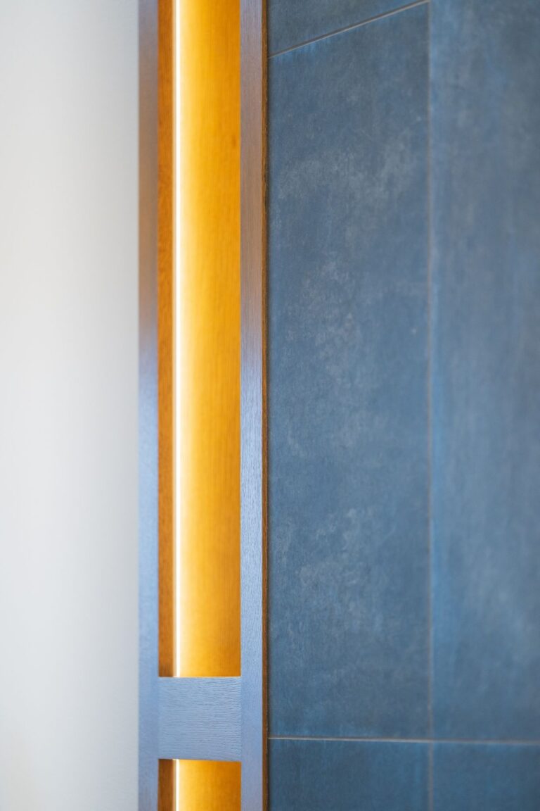 Elegant design detail combining natural wood, integrated lighting, and dark stone panels for a modern aesthetic.